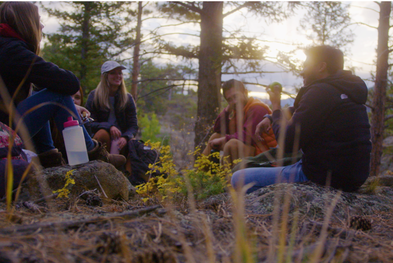 students sitting around campfire